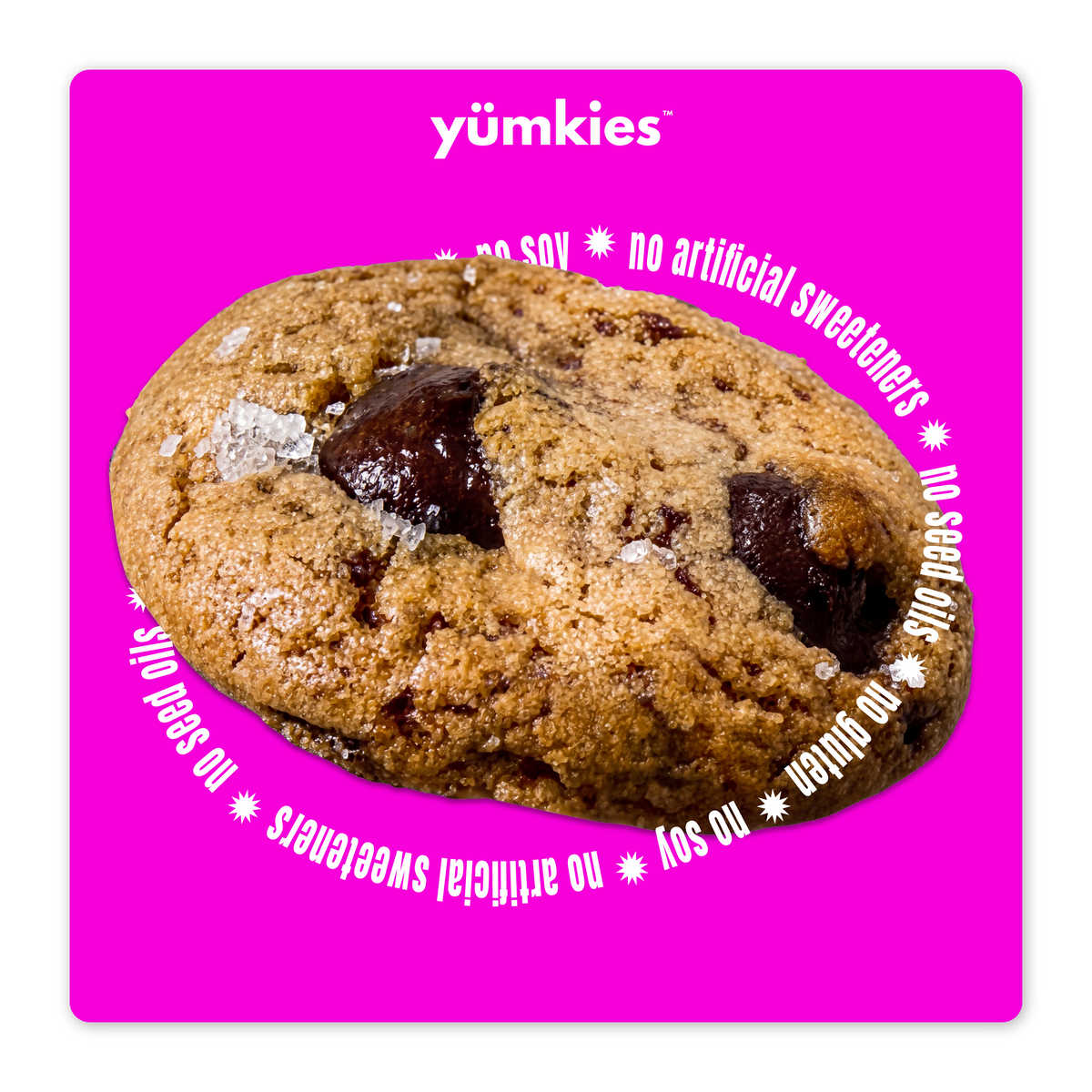 A chocolate chip cookie centered on a bright pink square background with the brand name yumkies at the top and white text around the cookie reading 'no soy', 'no artificial sweeteners', 'no seed oil', and 'no gluten