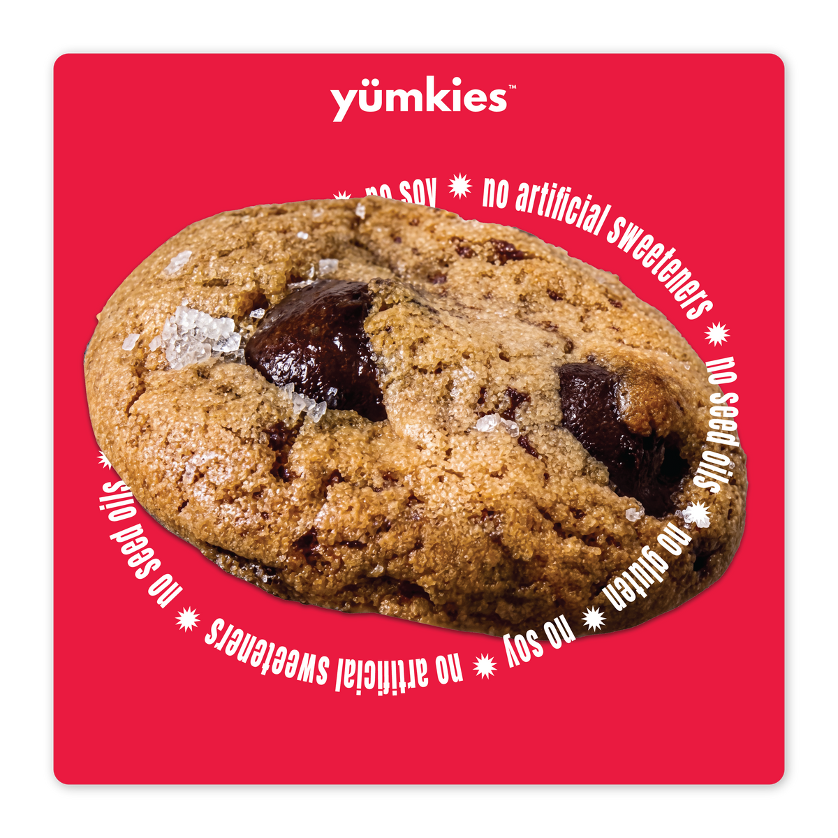 Yumkies chocolate chip protein cookie with melted chocolate chunks and flaky sea salt on a bright red background.